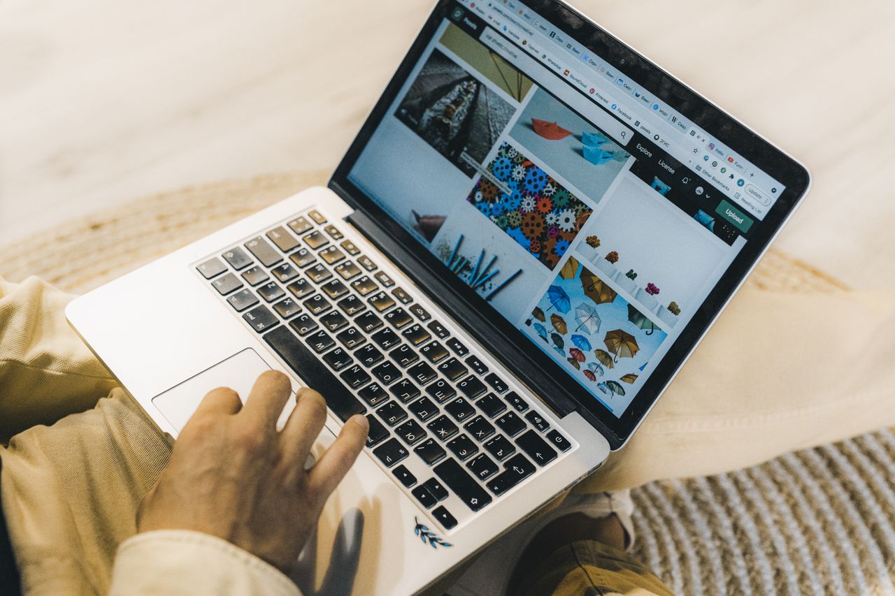 about-us-02 A person using a laptop to browse stock photo websites. Freelancing work in a cozy setting.
